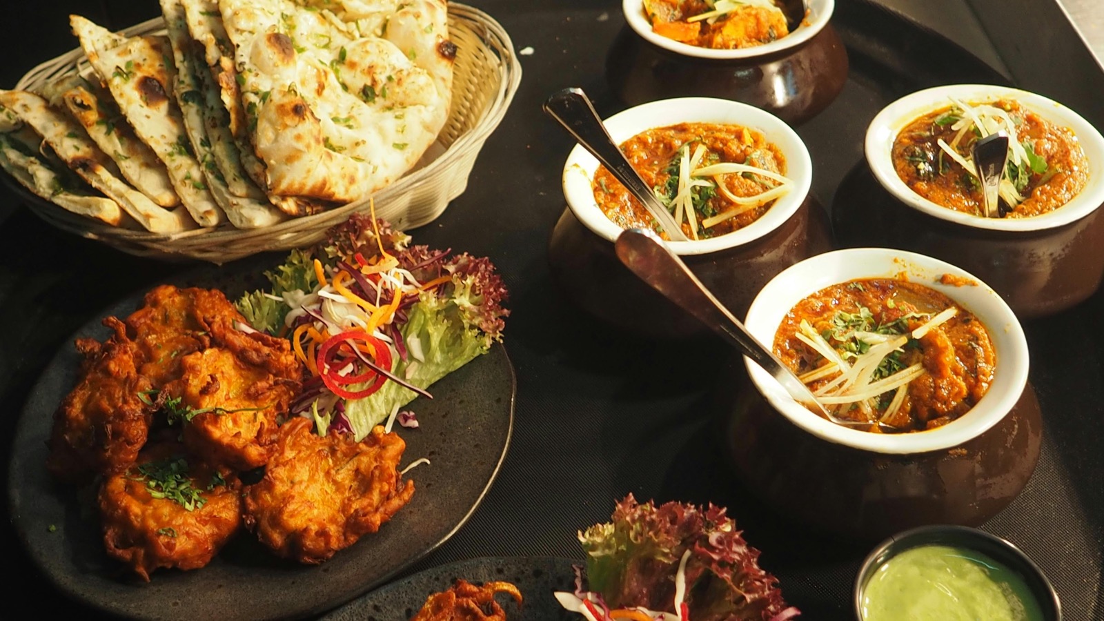 Indian meal with naan, curries, salad, and pakoras ready to be logged